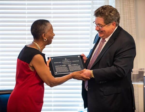 David Ross presents Cathy Hudgins with a plaque commemorating the naming of the Hudgins Community Theater at Hunters Woods at Trails Edge