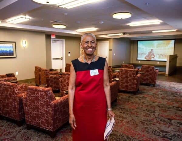 Cathy Hudgins poses in the Hudgins Community Theater at Hunters Woods at Trails Edge, named in honor of her and her husband Willie