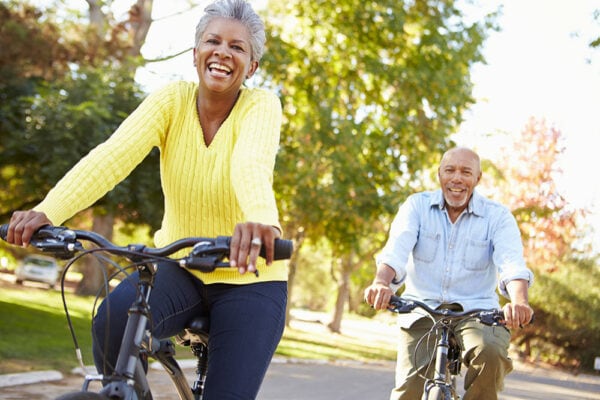 Senior couple riding bikes, happy outside