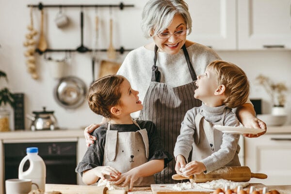 Senior woman baking in kitchen with grandkids