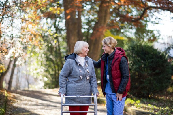 Senior woman and caregiver on a walk outdoors