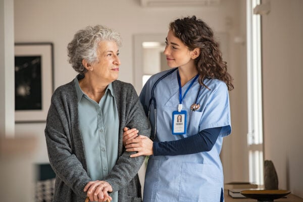 Senior woman walking with her caregiver