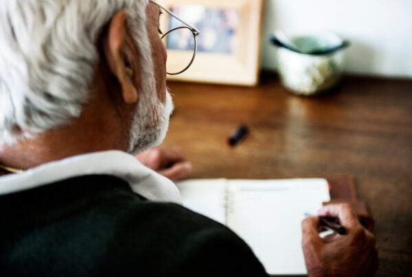 A senior man writes in his journal