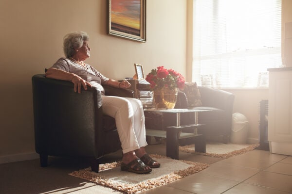 A senior woman sitting in a chair at home