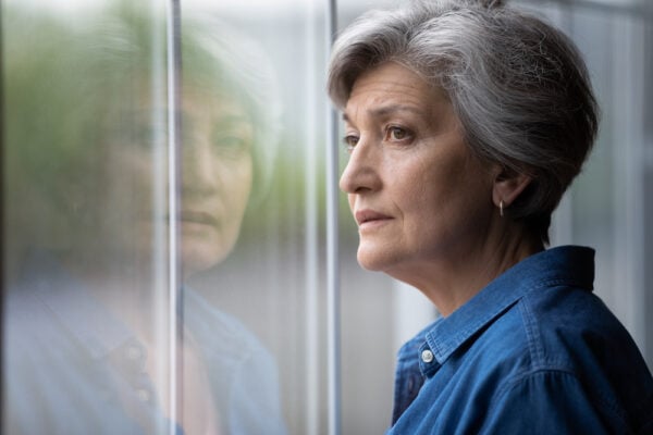 A senior woman looking out of a window