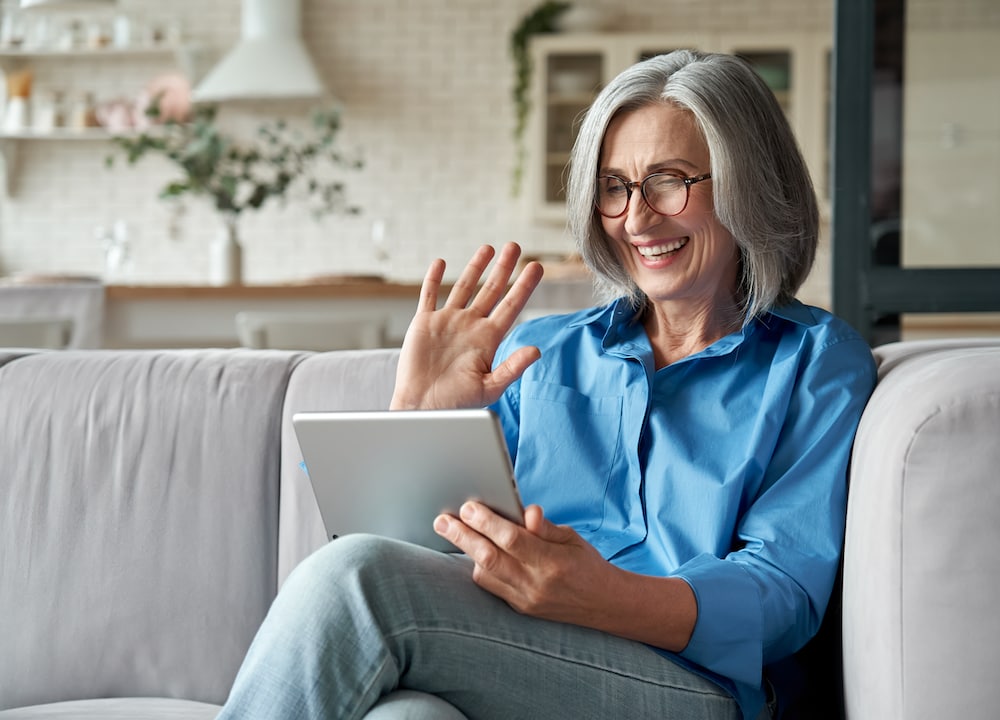 A senior woman uses her tablet to video chat with her doctor