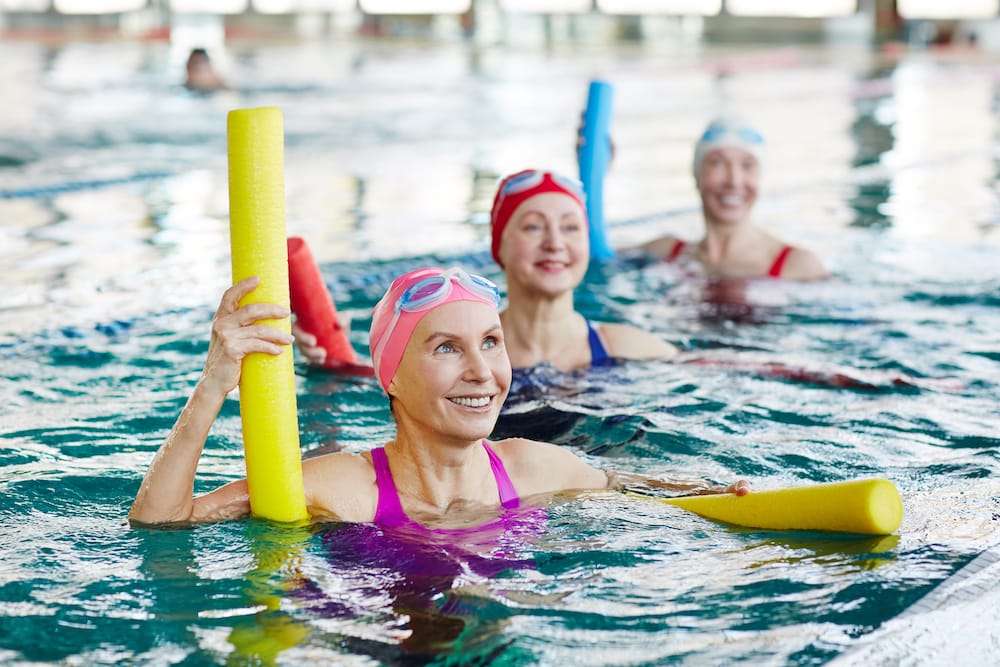 Senior women attend a water aerobics class