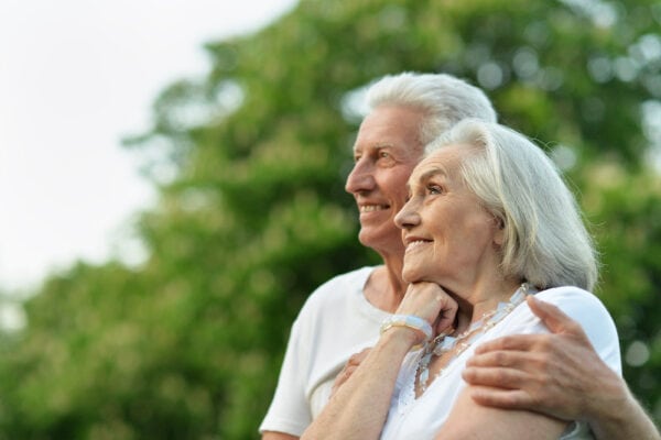 A happy couple sits in a park outdoors