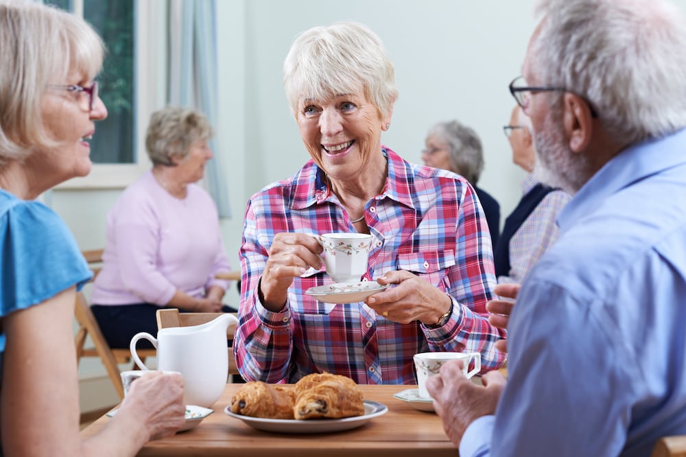 A group of senior friends enjoy coffee together