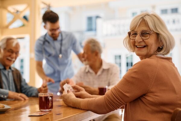 A happy group of senior friends play cards together