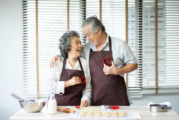 A happy senior couple bakes Valentine's Day cookies together