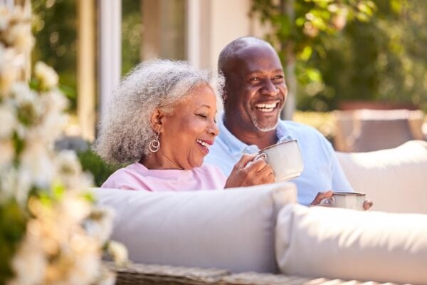 A happy senior couple drinking coffee on their patio