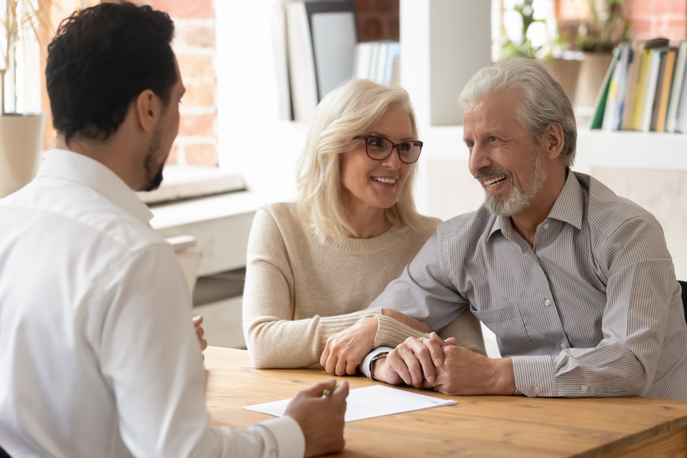 A senior couple sits down to work out a plan with a financial advisor