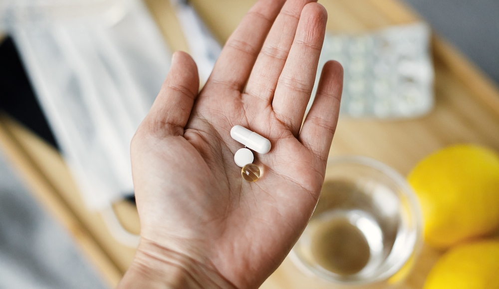 A senior woman holding vitamins and meds in her palm