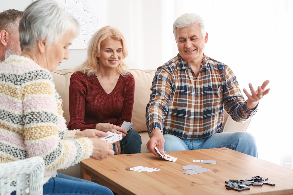 Four senior friends play a card game