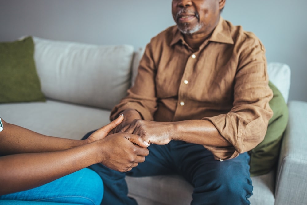 A senior man holding hands with a female family member