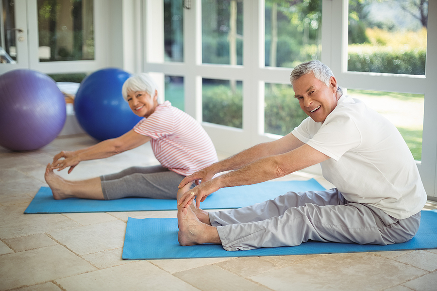Senior couple performing stretching exercise