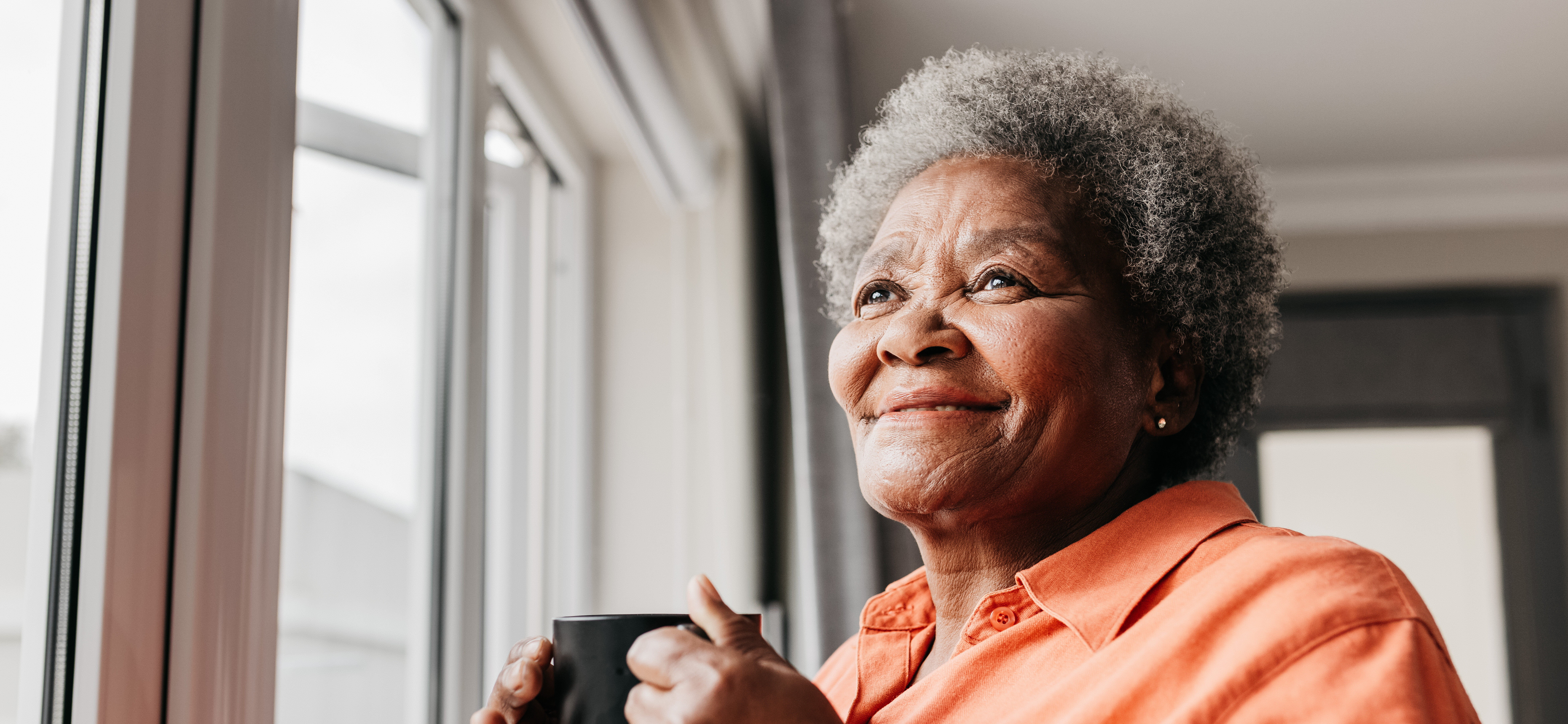Senior woman holding mug taking in views