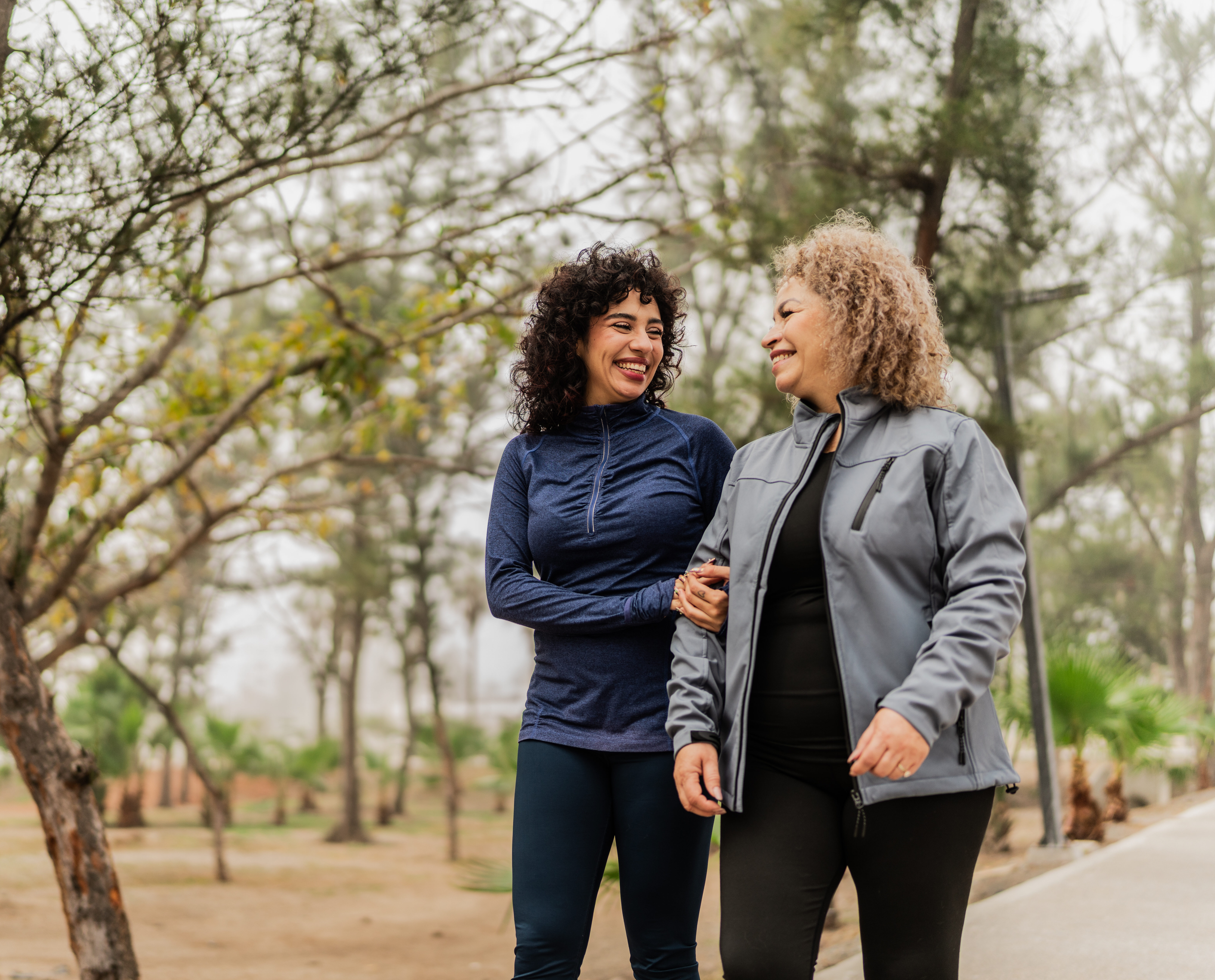 Mother and daughter talking while walking through the public park