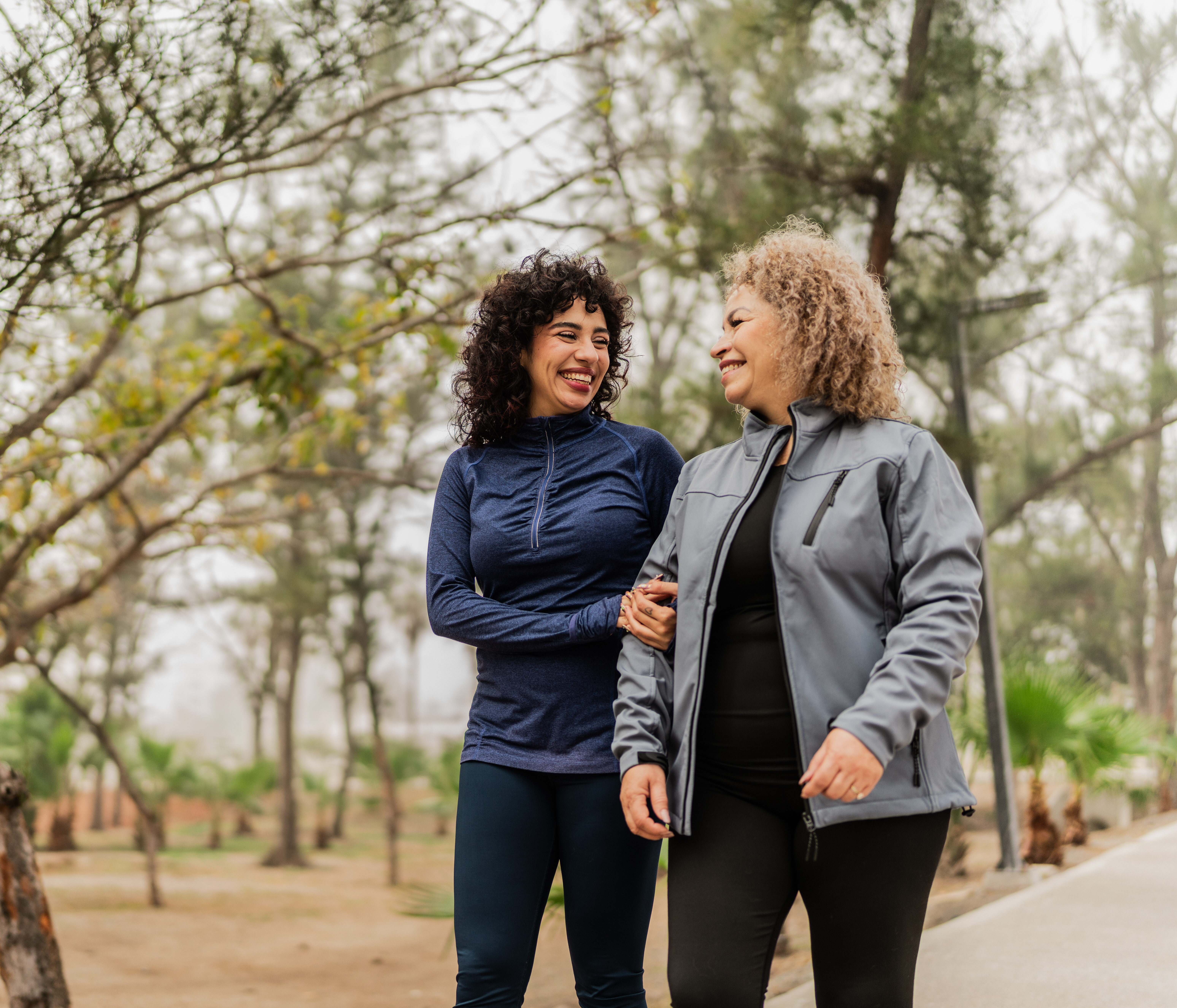 Mother and daughter talking while walking through the public park
