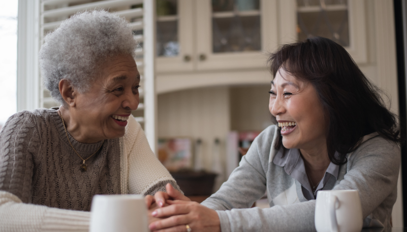 Two seniors talking together at a table