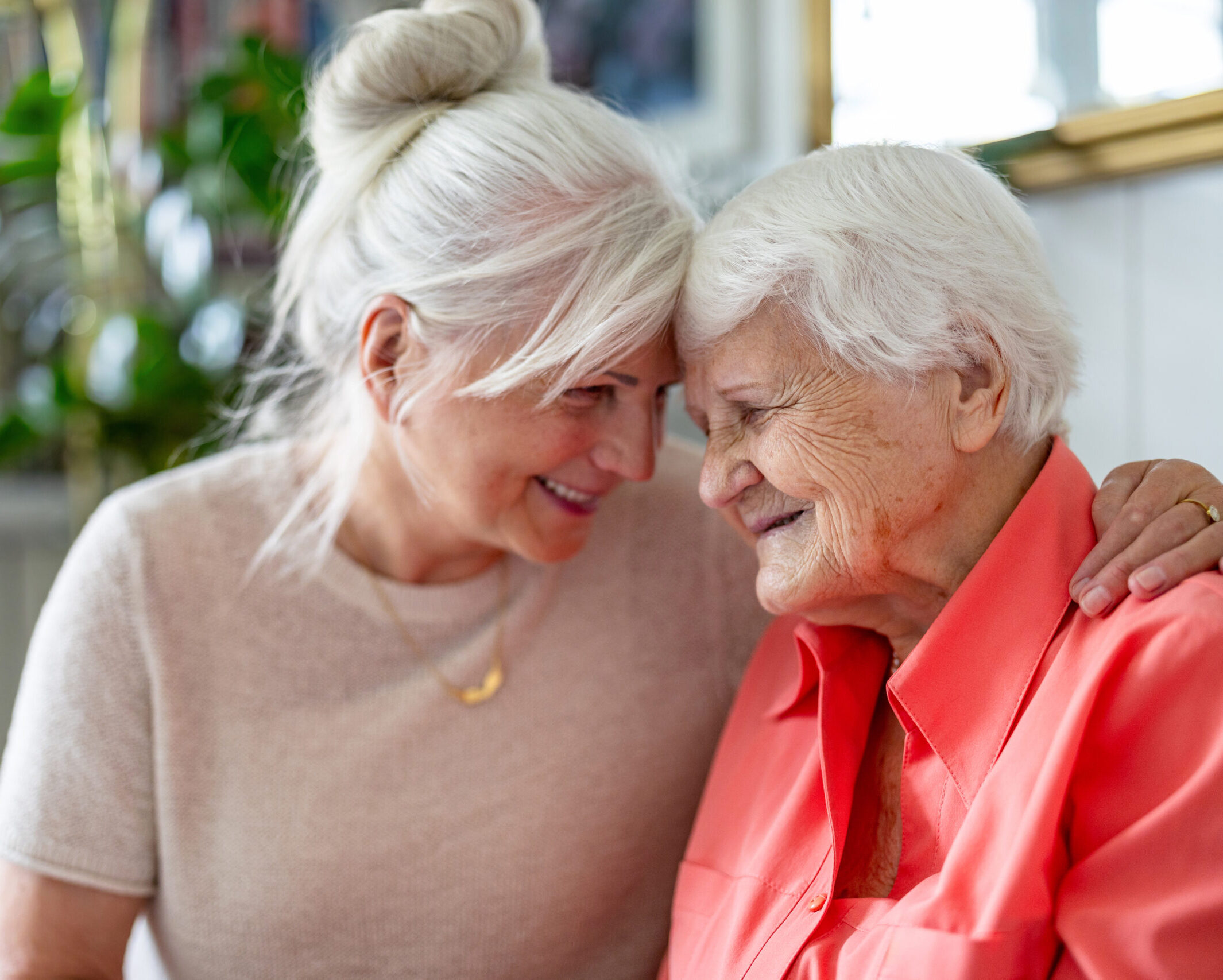 Happy senior woman with her adult daughter at home