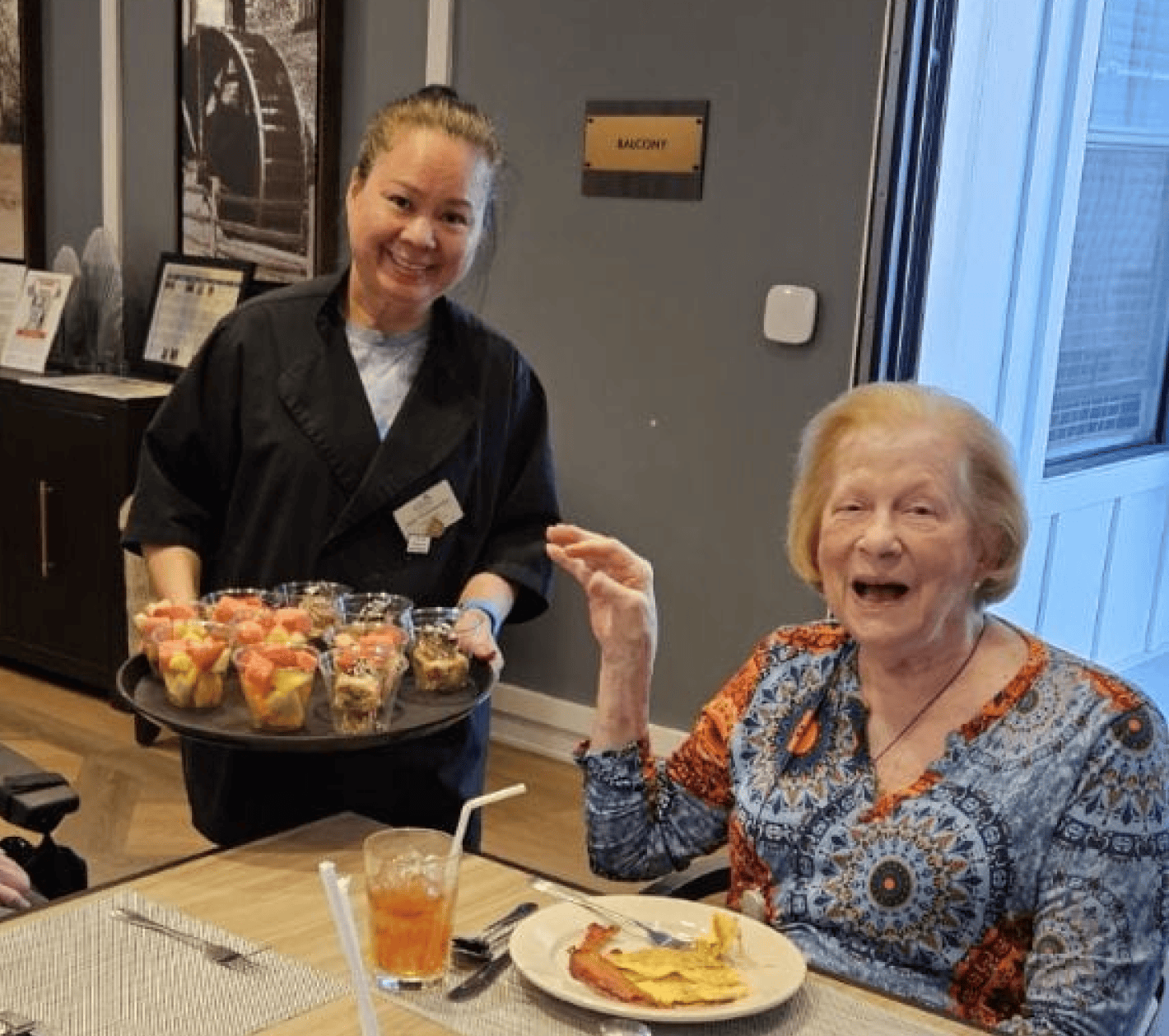 female residents smiling with a member of the culinary team