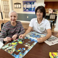 senior and highschool student doing a puzzle