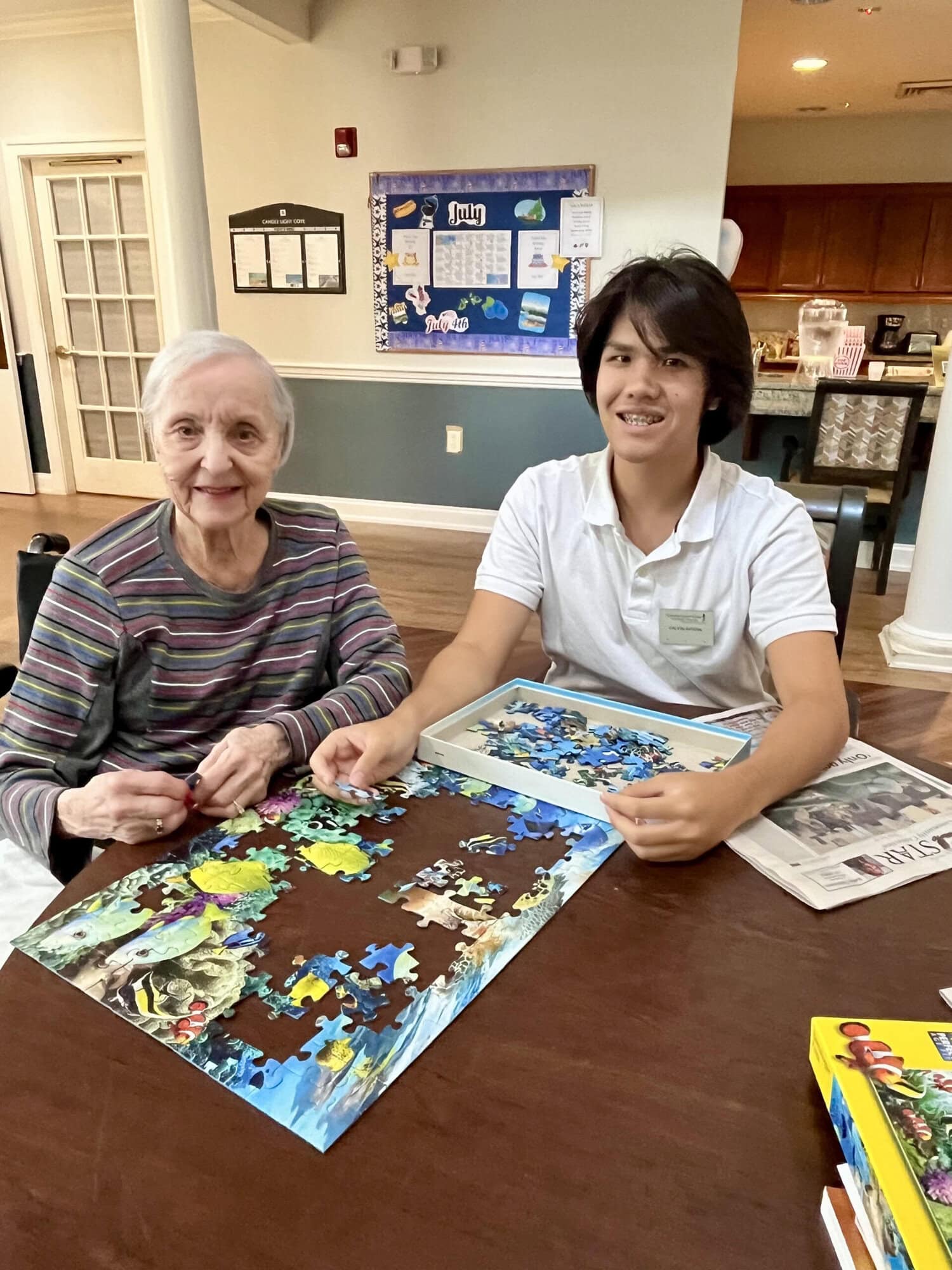 senior and highschool student doing a puzzle