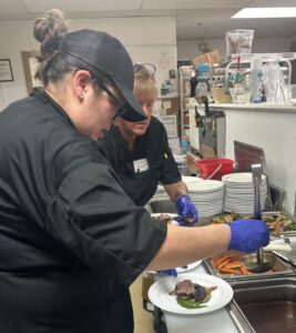 two women preparing dish