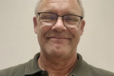 Photo of a man with glasses smiling