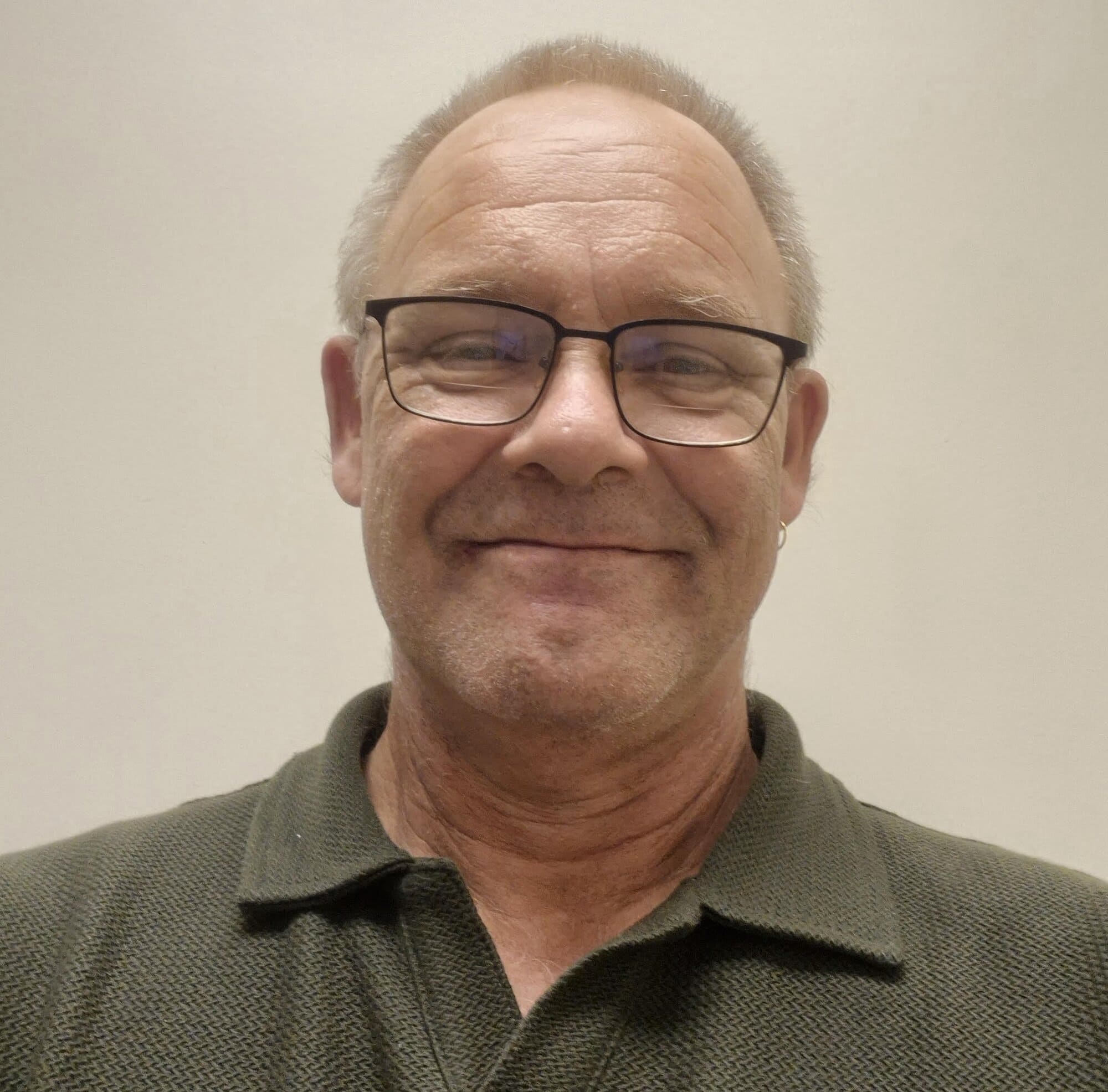 Photo of a man with glasses smiling