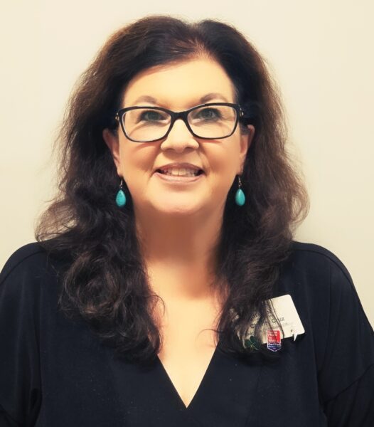 Charity Cruz, EOO at The Residence at Fitz Farm, with dark hair, glasses, and a friendly smile.