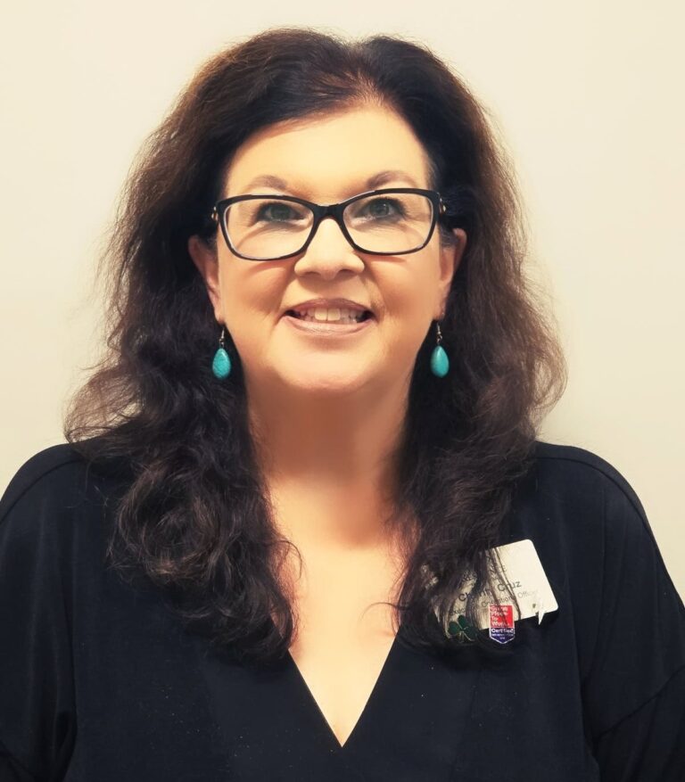 Charity Cruz, EOO at The Residence at Fitz Farm, with dark hair, glasses, and a friendly smile.