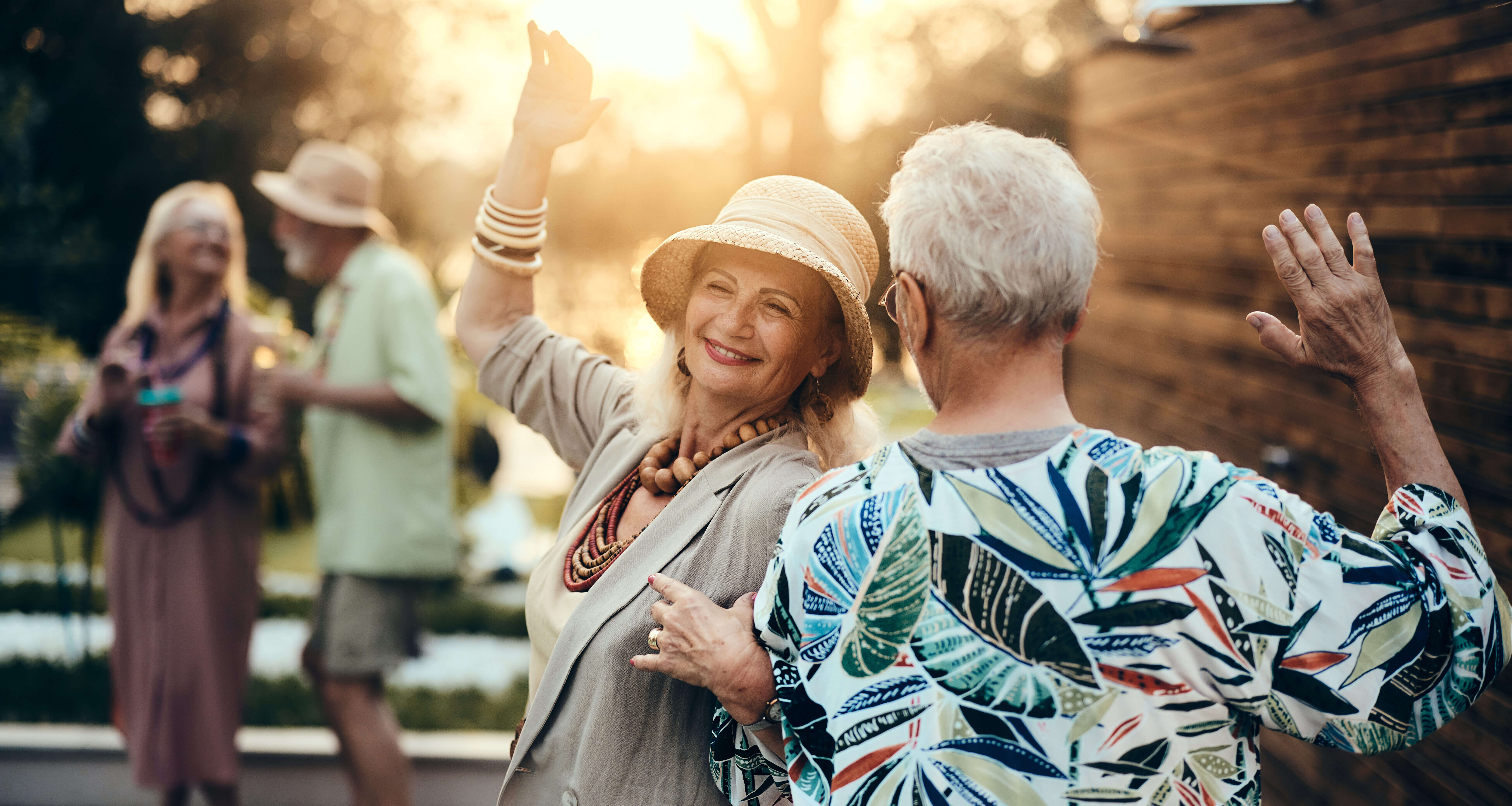 Senior friends dancing at sunset