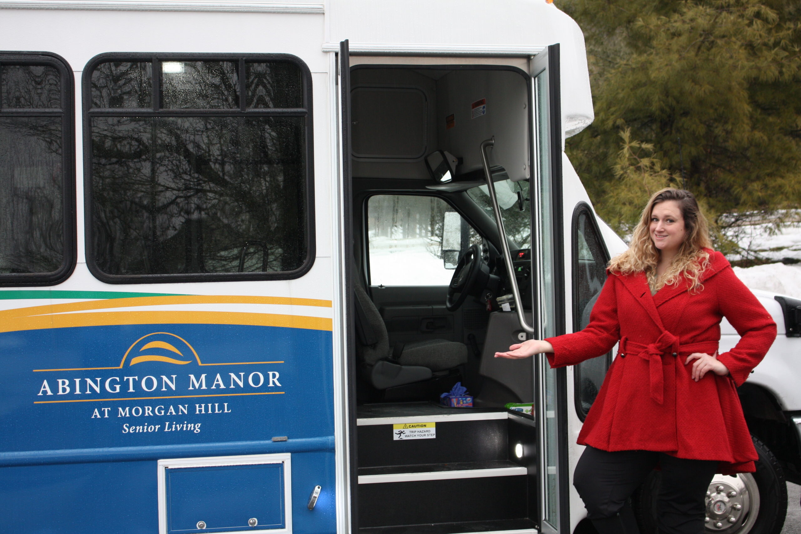 Natasha Foster, LifeStages Director, standing beside the new Abington Manor at Morgan Hill senior living community bus in Easton, PA.