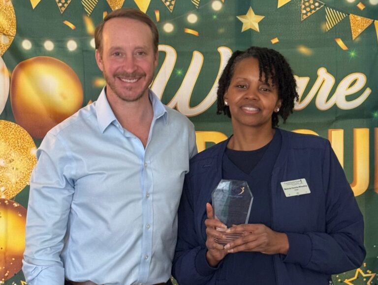 Melinda Dennis-Wheatley, an exceptional caregiver at Candle Light Cove, holding her 2025 National Ceca Award trophy next to Ceca President Nate Hamme.