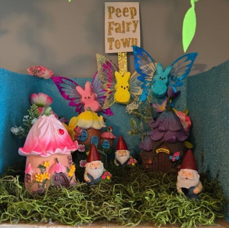 Peep Fairy Town" diorama at the Magnolias of Lancaster event featuring garden gnomes, miniature floral houses, and colorful marshmallow Peep bunnies with glittery butterfly wings on a mossy background.